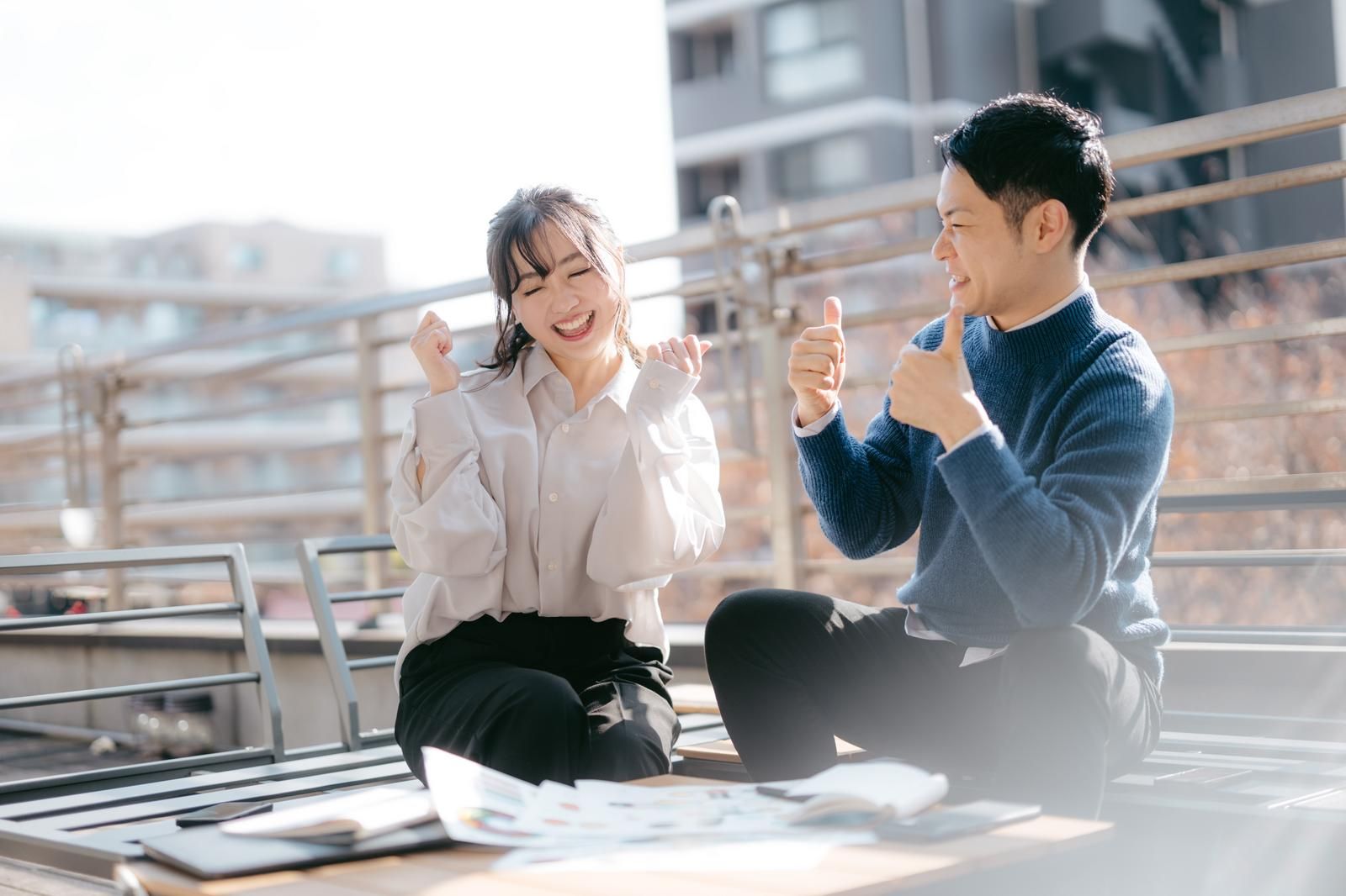 打ち合わせで喜ぶ男女社員