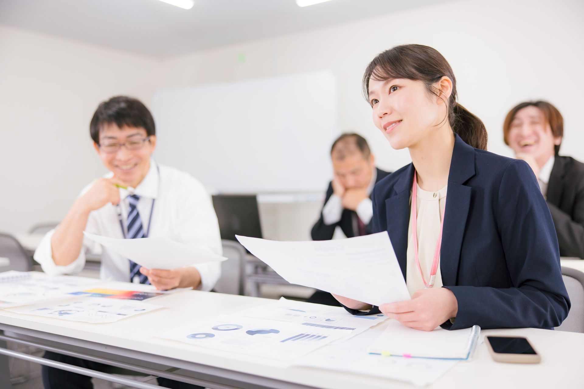 和やかな雰囲気でミーティング中に資料を確認する女性