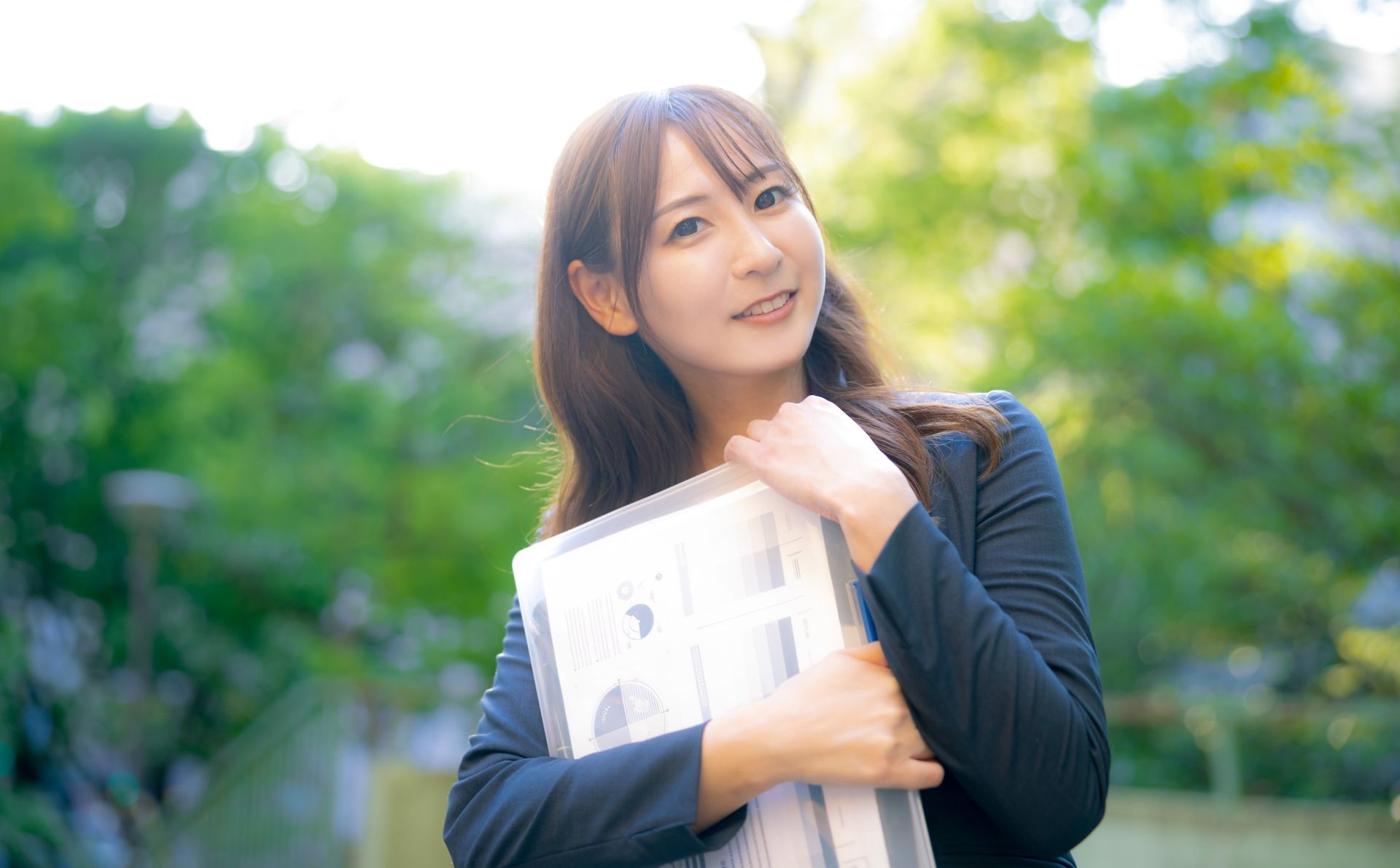 書類を抱えて笑顔を見せる女性